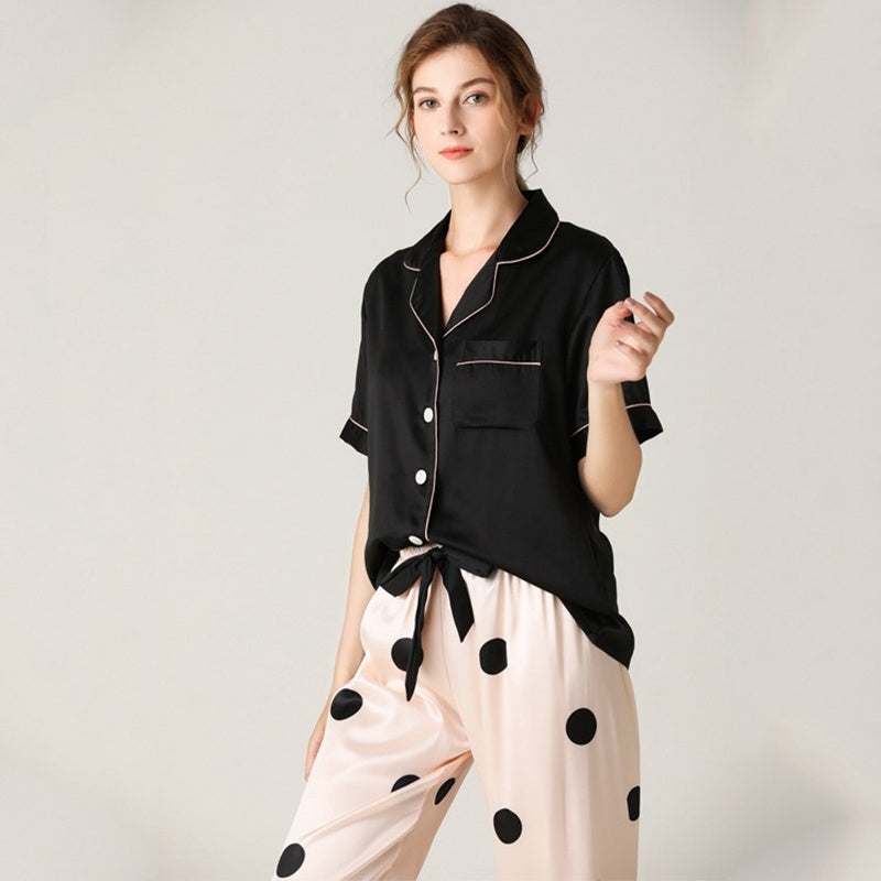Women wearing black imitation silk pajamas top with cream pants featuring large black polka dots